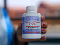 A Nepali health worker displays a bottle containing a Vitamin A capsule in Kathmandu, Nepal, on October 18, 2024. (