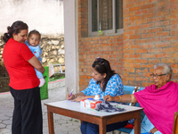 A Nepali health worker (C) records details of a child (L) before administering a ''Vitamin A'' capsule at an inoculation center in Kathmandu...