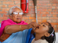 A Nepali child receives a ''Vitamin A'' capsule at an inoculation center in Kathmandu, Nepal, on October 18, 2024. (