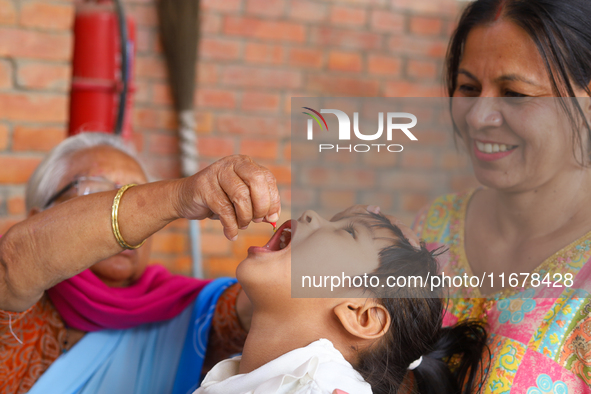 A Nepali child receives a ''Vitamin A'' capsule at an inoculation center in Kathmandu, Nepal, on October 18, 2024. 