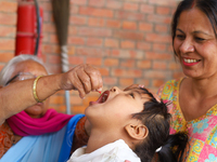 A Nepali child receives a ''Vitamin A'' capsule at an inoculation center in Kathmandu, Nepal, on October 18, 2024. (