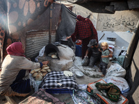 A Palestinian woman bakes bread at a makeshift camp for the internally displaced in Deir al-Balah in the central Gaza Strip on October 18, 2...