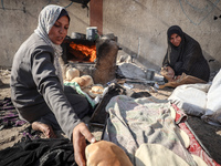 A Palestinian woman bakes bread at a makeshift camp for the internally displaced in Deir al-Balah in the central Gaza Strip on October 18, 2...