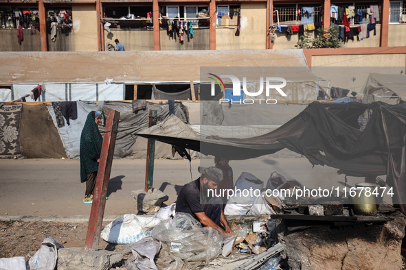 A Palestinian man bakes bread at a makeshift camp for the internally displaced in Deir al-Balah in the central Gaza Strip on October 18, 202...