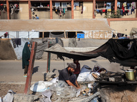 A Palestinian man bakes bread at a makeshift camp for the internally displaced in Deir al-Balah in the central Gaza Strip on October 18, 202...