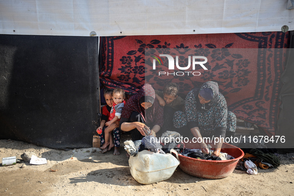 Palestinian women wash their clothes at a makeshift camp for the internally displaced in Deir al-Balah, Gaza Strip, on October 18, 2024, ami...