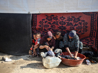 Palestinian women wash their clothes at a makeshift camp for the internally displaced in Deir al-Balah, Gaza Strip, on October 18, 2024, ami...