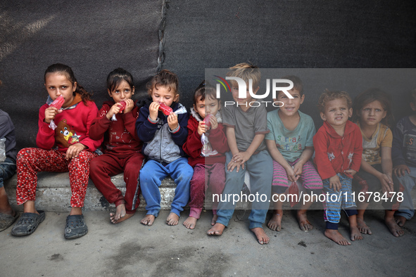 Displaced Palestinian children sit in front of a tent at a makeshift camp for the internally displaced in Deir al-Balah in the central Gaza...