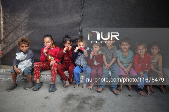 Displaced Palestinian children sit in front of a tent at a makeshift camp for the internally displaced in Deir al-Balah in the central Gaza...