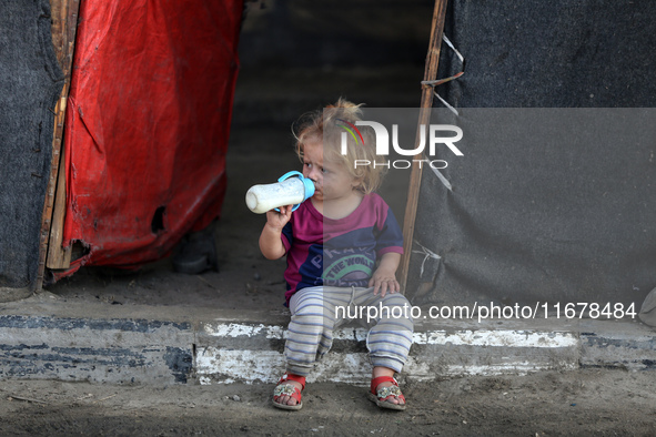 A displaced Palestinian child sits in front of a tent in a temporary camp for internally displaced persons in Deir al-Balah, central Gaza St...