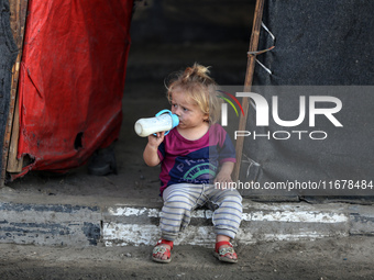 A displaced Palestinian child sits in front of a tent in a temporary camp for internally displaced persons in Deir al-Balah, central Gaza St...