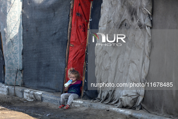 A displaced Palestinian child sits in front of a tent in a temporary camp for internally displaced persons in Deir al-Balah, central Gaza St...