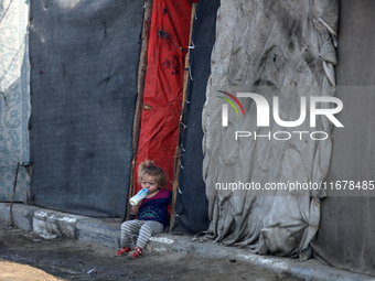 A displaced Palestinian child sits in front of a tent in a temporary camp for internally displaced persons in Deir al-Balah, central Gaza St...