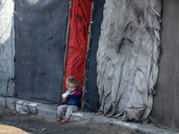 A displaced Palestinian child sits in front of a tent in a temporary camp for internally displaced persons in Deir al-Balah, central Gaza St...