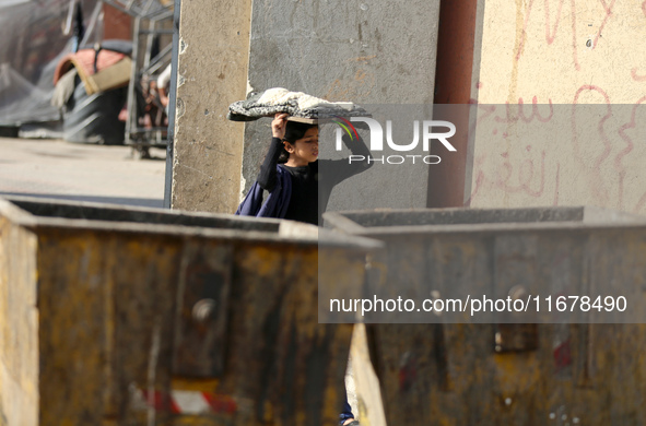 A Palestinian girl carries freshly baked loaves of bread back to her family at a makeshift camp for the internally displaced in Deir al-Bala...