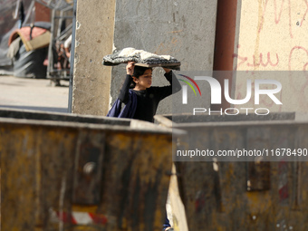 A Palestinian girl carries freshly baked loaves of bread back to her family at a makeshift camp for the internally displaced in Deir al-Bala...