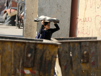 A Palestinian girl carries freshly baked loaves of bread back to her family at a makeshift camp for the internally displaced in Deir al-Bala...