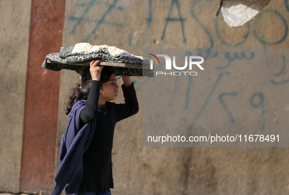 A Palestinian girl carries freshly baked loaves of bread back to her family at a makeshift camp for the internally displaced in Deir al-Bala...