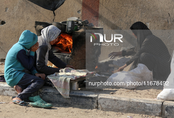 A Palestinian woman bakes bread at a makeshift camp for the internally displaced in Deir al-Balah in the central Gaza Strip on October 18, 2...