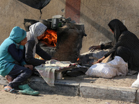 A Palestinian woman bakes bread at a makeshift camp for the internally displaced in Deir al-Balah in the central Gaza Strip on October 18, 2...