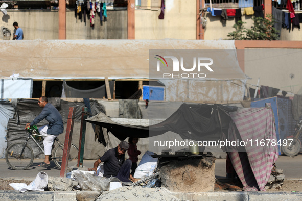 A Palestinian man bakes bread at a makeshift camp for the internally displaced in Deir al-Balah in the central Gaza Strip on October 18, 202...