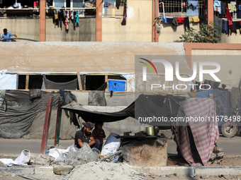 A Palestinian man bakes bread at a makeshift camp for the internally displaced in Deir al-Balah in the central Gaza Strip on October 18, 202...