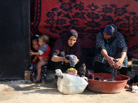 Palestinian women wash their clothes at a makeshift camp for the internally displaced in Deir al-Balah, Gaza Strip, on October 18, 2024, ami...