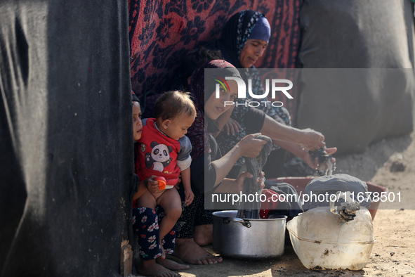 Palestinian women wash their clothes at a makeshift camp for the internally displaced in Deir al-Balah, Gaza Strip, on October 18, 2024, ami...