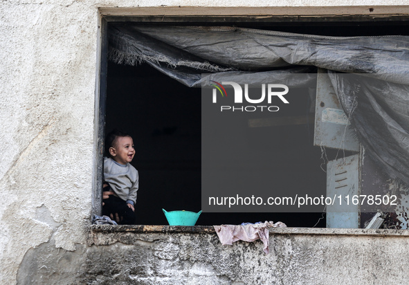 A Palestinian boy peeks from inside a tent at a makeshift camp for the internally displaced in Deir al-Balah in the central Gaza Strip on Oc...