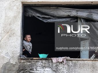 A Palestinian boy peeks from inside a tent at a makeshift camp for the internally displaced in Deir al-Balah in the central Gaza Strip on Oc...