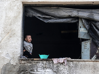 A Palestinian boy peeks from inside a tent at a makeshift camp for the internally displaced in Deir al-Balah in the central Gaza Strip on Oc...