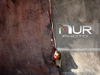 A Palestinian boy peeks from inside a tent at a makeshift camp for the internally displaced in Deir al-Balah in the central Gaza Strip on Oc...