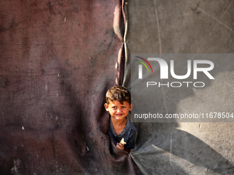 A Palestinian boy peeks from inside a tent at a makeshift camp for the internally displaced in Deir al-Balah in the central Gaza Strip on Oc...