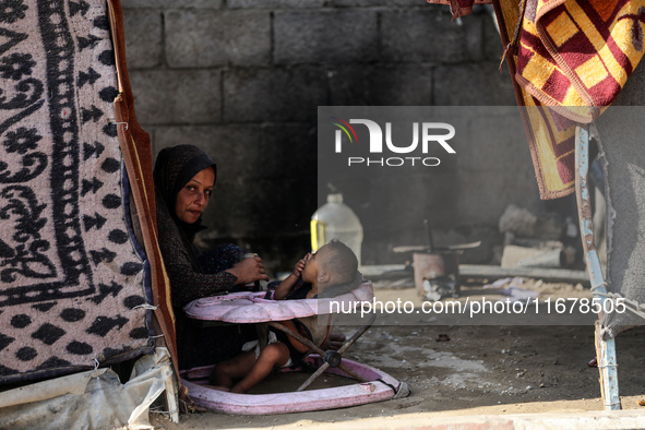 A Palestinian boy peeks from inside a tent at a makeshift camp for the internally displaced in Deir al-Balah in the central Gaza Strip on Oc...