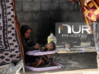 A Palestinian boy peeks from inside a tent at a makeshift camp for the internally displaced in Deir al-Balah in the central Gaza Strip on Oc...