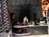 A Palestinian boy peeks from inside a tent at a makeshift camp for the internally displaced in Deir al-Balah in the central Gaza Strip on Oc...