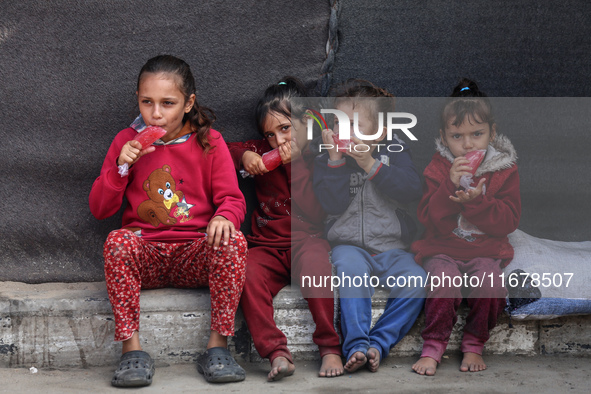 Displaced Palestinian children sit in front of a tent at a makeshift camp for the internally displaced in Deir al-Balah in the central Gaza...