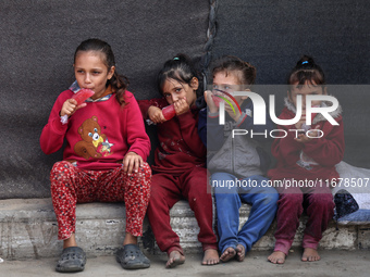 Displaced Palestinian children sit in front of a tent at a makeshift camp for the internally displaced in Deir al-Balah in the central Gaza...