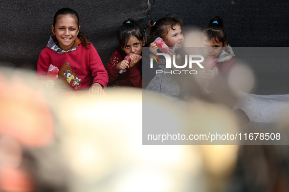 Displaced Palestinian children sit in front of a tent at a makeshift camp for the internally displaced in Deir al-Balah in the central Gaza...