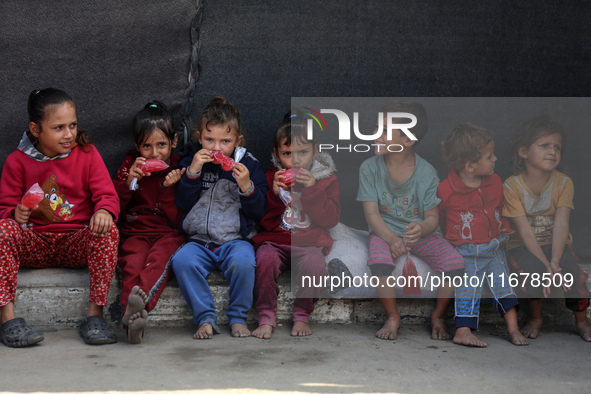 Displaced Palestinian children sit in front of a tent at a makeshift camp for the internally displaced in Deir al-Balah in the central Gaza...