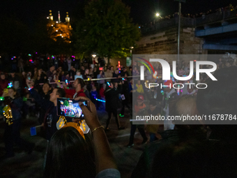 Spectators and participants are seen during the 2024 Blink Art and Light Festival in Cincinnati, Ohio, on October 17, 2024. (