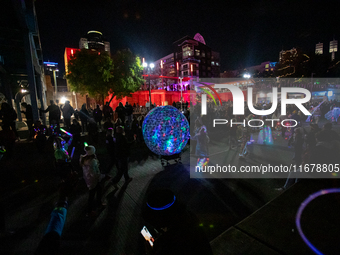 Spectators and participants are seen during the 2024 Blink Art and Light Festival in Cincinnati, Ohio, on October 17, 2024. (