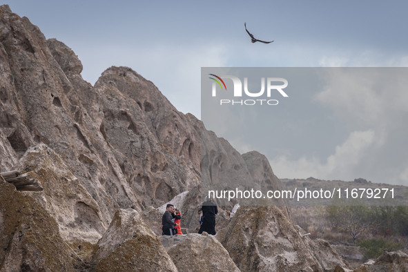 An eagle flies as tourists stand in the Kandovan cliff village, 650 km (400 miles) northwest of Tehran, Iran, on October 18, 2024. Kandovan...