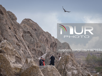 An eagle flies as tourists stand in the Kandovan cliff village, 650 km (400 miles) northwest of Tehran, Iran, on October 18, 2024. Kandovan...