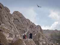 An eagle flies as tourists stand in the Kandovan cliff village, 650 km (400 miles) northwest of Tehran, Iran, on October 18, 2024. Kandovan...