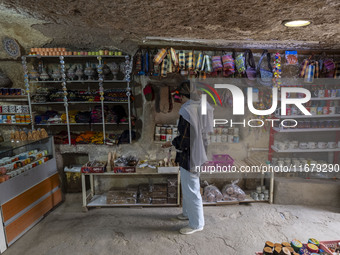 A young Iranian woman looks at goods while shopping during her visit to the Kandovan cliff village in Kandovan, Iran, on October 18, 2024. K...