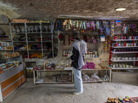 A young Iranian woman looks at goods while shopping during her visit to the Kandovan cliff village in Kandovan, Iran, on October 18, 2024. K...