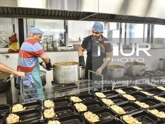 Lebanese volunteers prepare food portions for displaced people at Father Hani Tawk's charitable facility, Mariam's Kitchen, in Beirut, Leban...