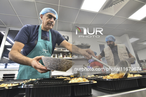 Lebanese volunteers prepare food portions for displaced people at Father Hani Tawk's charitable facility, Mariam's Kitchen, in Beirut, Leban...