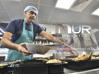 Lebanese volunteers prepare food portions for displaced people at Father Hani Tawk's charitable facility, Mariam's Kitchen, in Beirut, Leban...